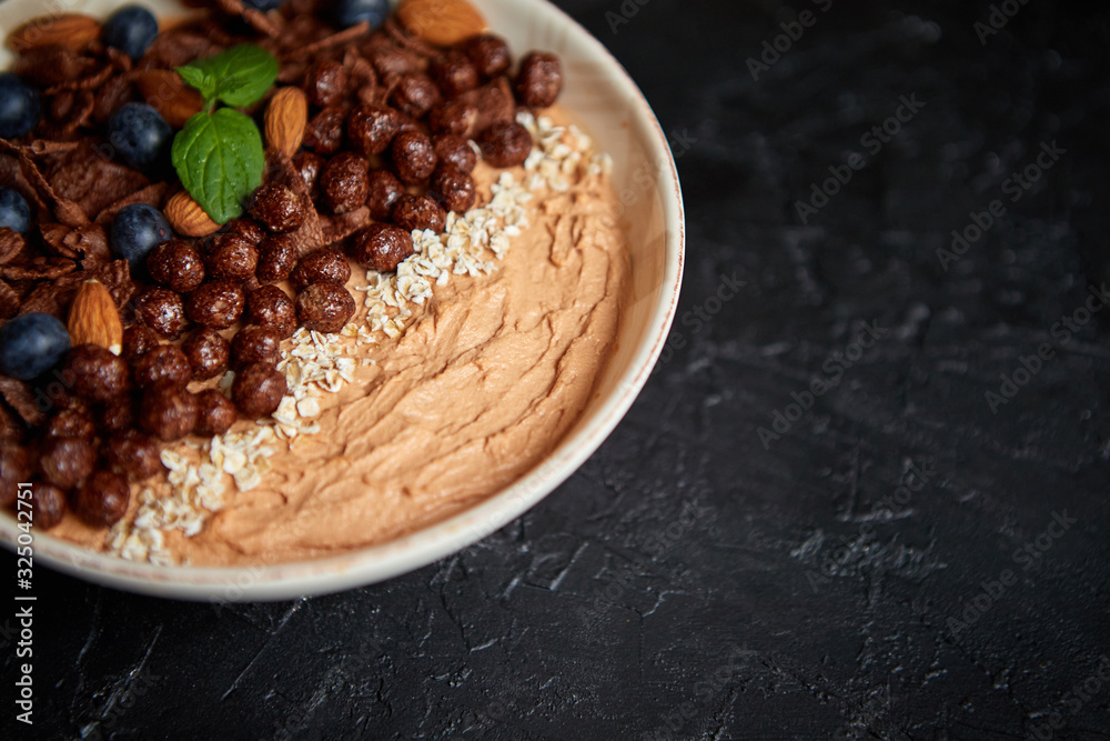 Chocolate and blueberry smoothie or yogurt. With cocoa cornflakes, granola, mint leaves and almonds Chocolate and blueberry smoothie or yogurt. With cocoa cornflakes, granola, mint leaves and almonds