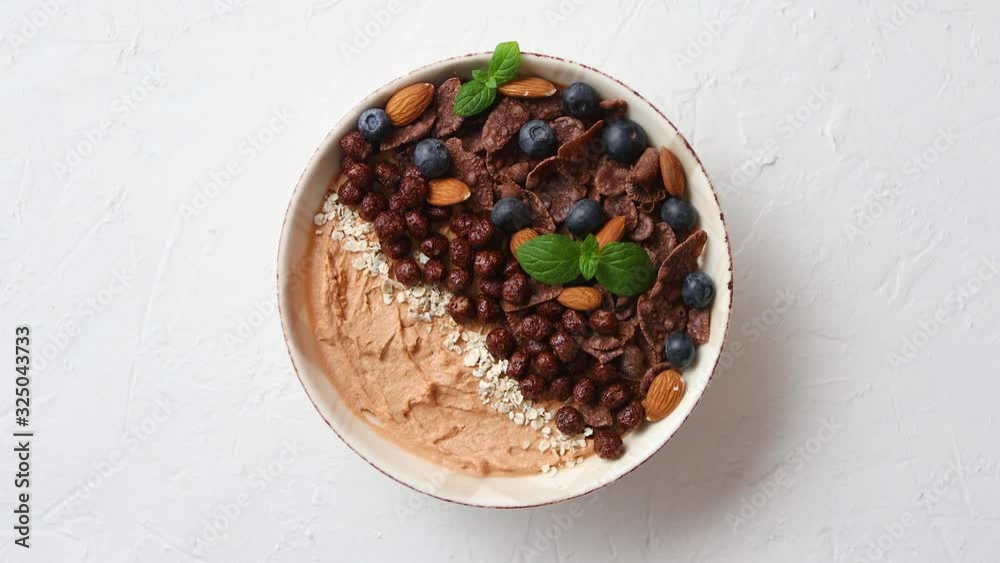 Chocolate and blueberry smoothie or yogurt. With cocoa cornflakes, granola, mint leaves and almonds Chocolate and blueberry smoothie or yogurt. With cocoa cornflakes, granola, mint leaves and almonds
