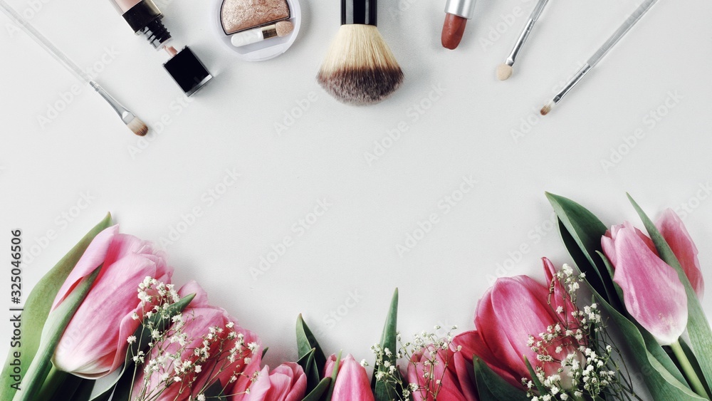 Beautiful spring flowers bouquet with cosmetics for greetings isolated on white