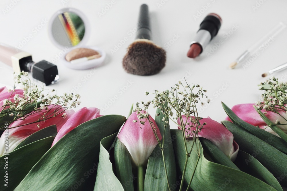 Beautiful spring flowers bouquet with cosmetics for greetings isolated on white
