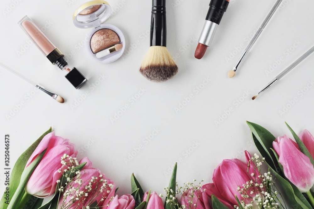 Beautiful spring flowers bouquet with cosmetics for greetings isolated on white