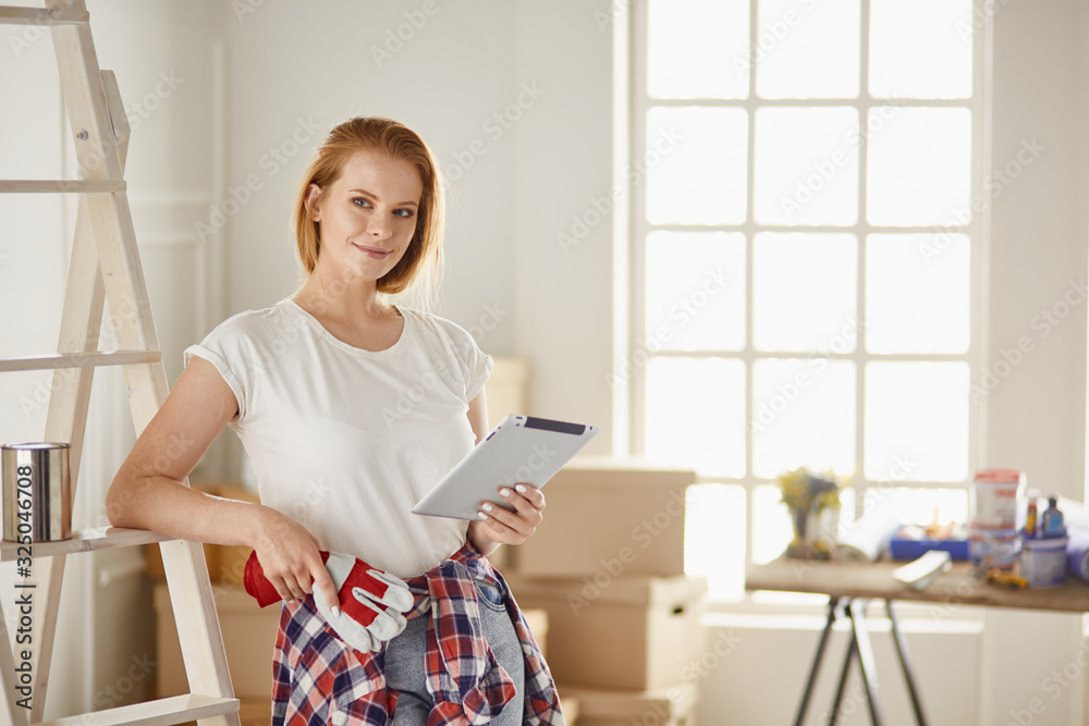 Beautiful young woman on a white wooden stepladder. Ready to repair the room. Women housework concept Beautiful young woman on a white wooden stepladder. Ready to repair the room. Women housework concept