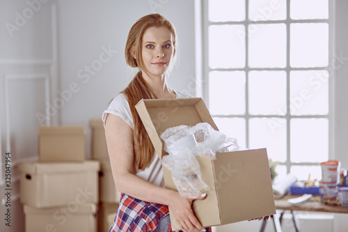 A beautiful single young woman unpacking boxes and moving into a new home