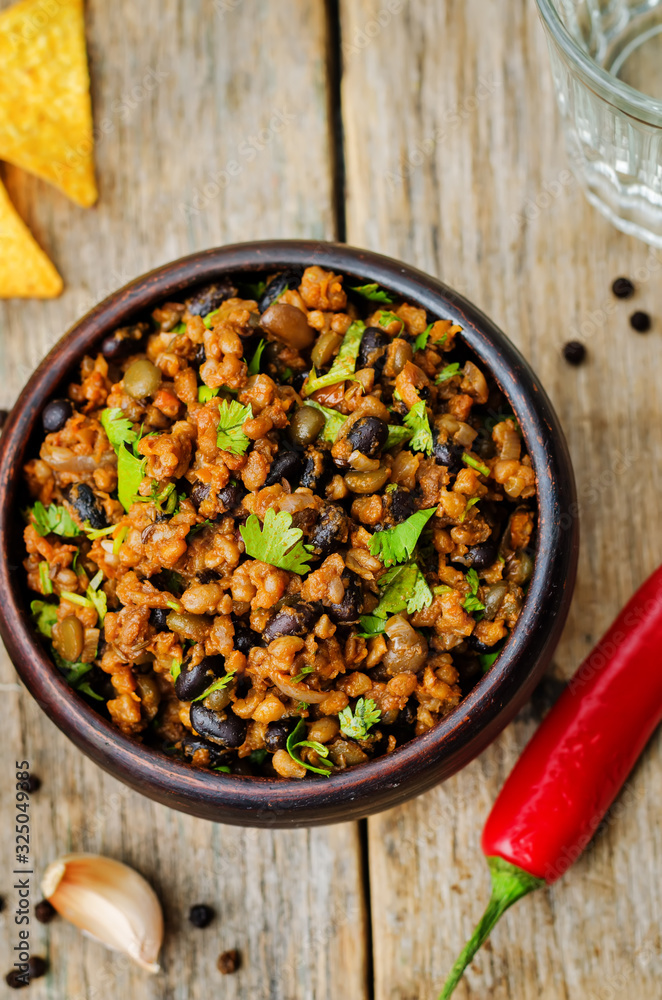 vegetarian chili with cilantro on a dark wood background vegetarian chili with cilantro on a dark wood background