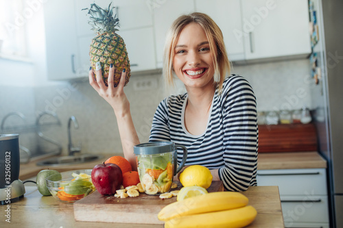 Young smiling woman with pineapple.