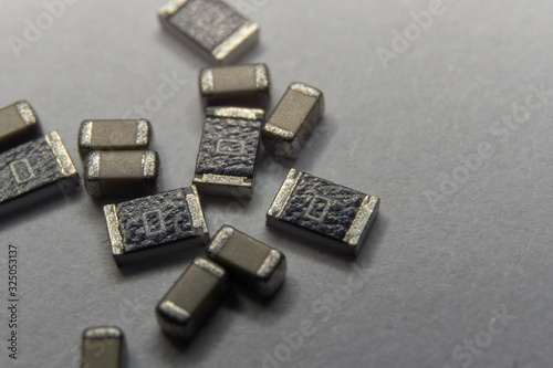 Abstract close-up scattered 0603 SMT MLCC capacitors, resistors electronics components white background random pattern photo