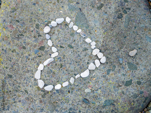 Heart lined with white stones on a large gray stone