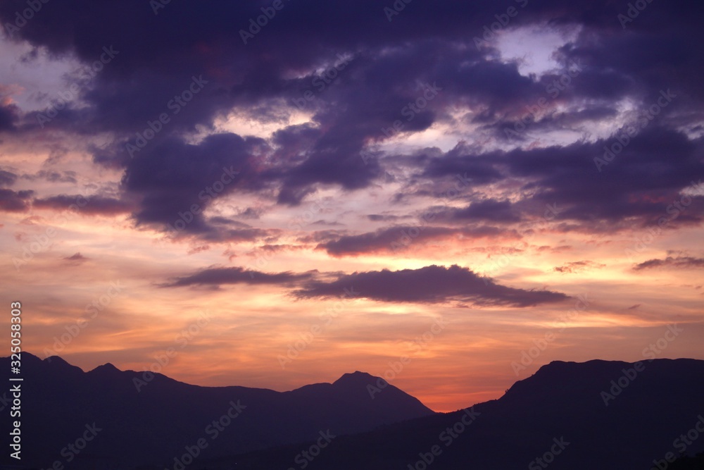 Obraz premium Silhouetted mountains and a brilliant sunset