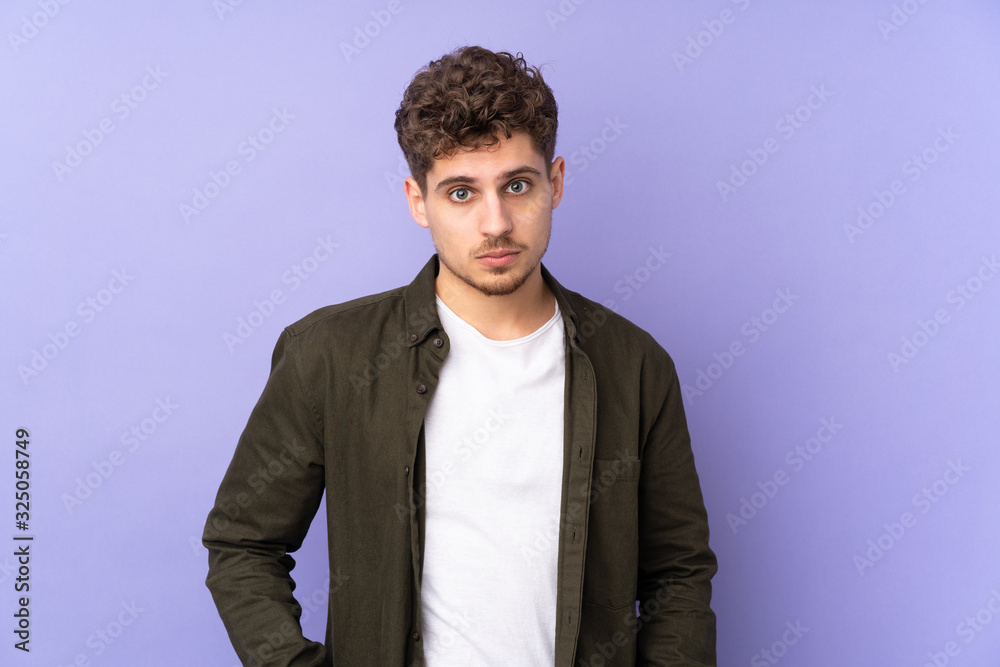 Fototapeta premium Caucasian man isolated on purple background with sad expression