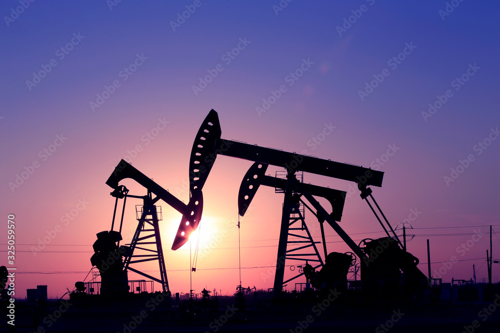 Oil pumps at work against the setting sun Oil pumps at work against the setting sun