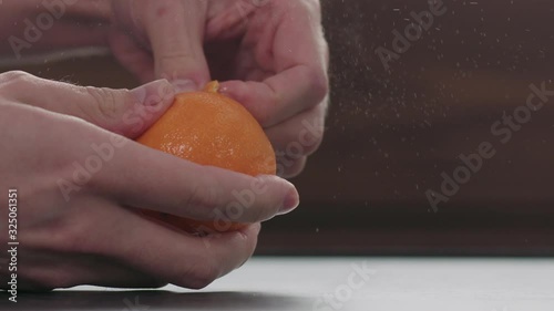 Slow motion man hands peeling tangerine slow motion photo