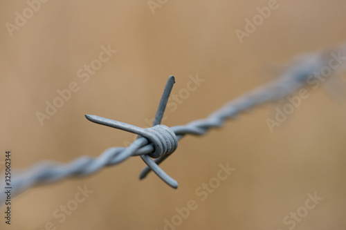 Piece of barb wire fence close up © Abinieks