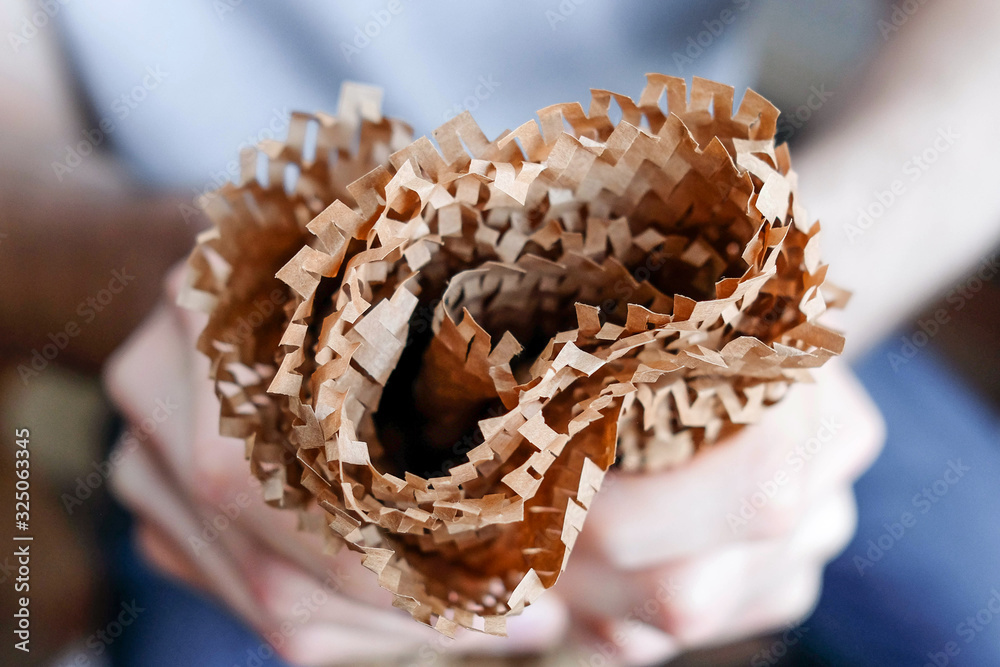 Brown paper in the hands. Thin packaging folded in several layers Brown paper in the hands. Thin packaging folded in several layers