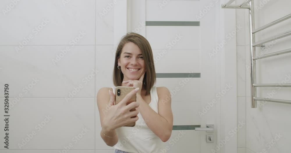 girl taking selfie in mirror in bathroom girl taking selfie in mirror in bathroom