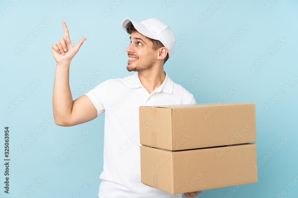 Delivery caucasian man isolated on blue background pointing with the index finger a great idea Delivery caucasian man isolated on blue background pointing with the index finger a great idea