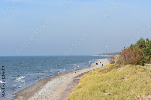 Beach landscape with steep dune coast blue sky Liepaja Skede Latvia photo