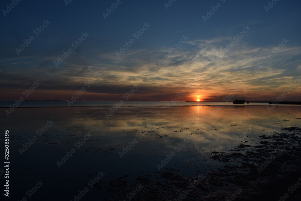 Fototapeta premium Beautiful orange sunset sky reflection on calm sea