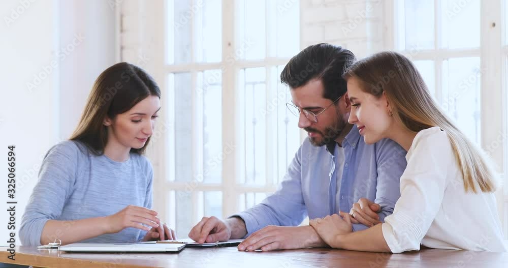 Happy young couple sign mortgage contract get keys handshake realtor Happy young couple sign mortgage contract get keys handshake realtor
