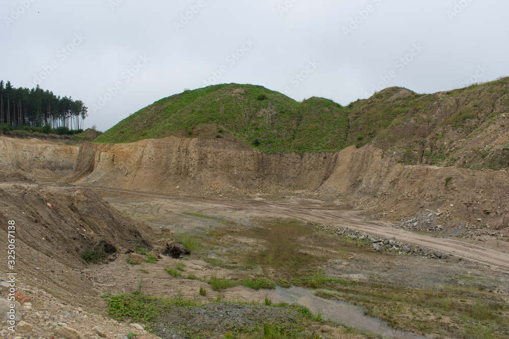 Landscape view of limestone quarry with high cliffs and canyons, and water