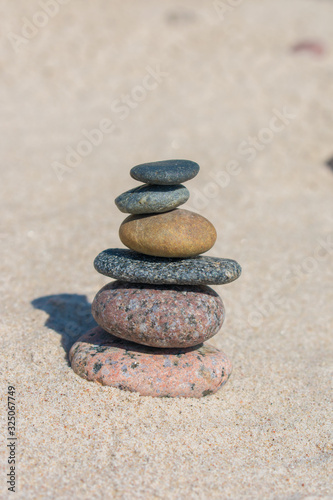 Stack of stones on sand beach near sea. Zen garden. Pebble tower.
