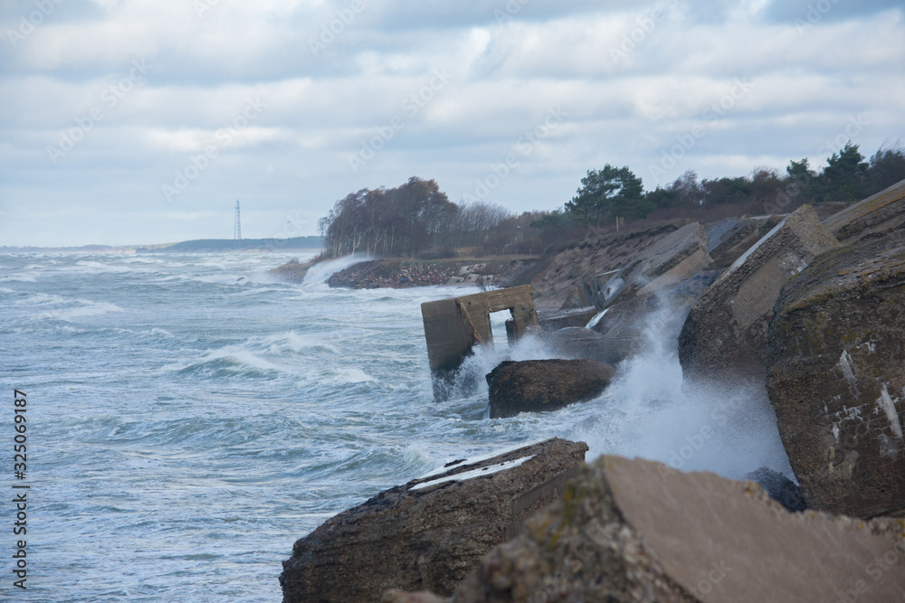 Waves crashing against breakwater consisting of gray concrete tetrapods. Liepaja, Latvia. Waves crashing against breakwater consisting of gray concrete tetrapods. Liepaja, Latvia.