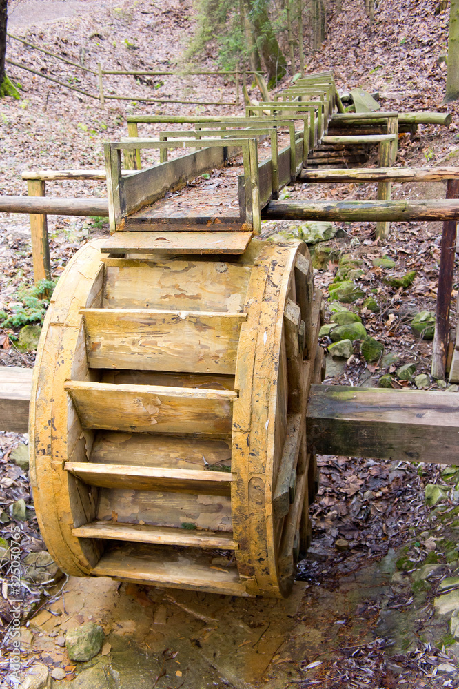 Old wooden water mill, standing in the bed of a dried-up river. Background for old gears and fixtures. Old wooden water mill, standing in the bed of a dried-up river. Background for old gears and fixtures.