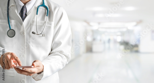 Fotografie Male doctor using mobile phone at hospital