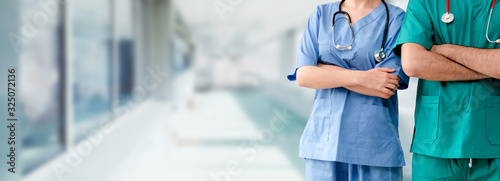 Two hospital staffs - surgeon, doctor or nurse standing with arms crossed in the hospital. Medical healthcare and doctor service. photo