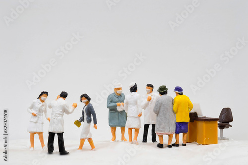 Miniature figure doll Group of Doctor Nurse and Patient wearing mask to Protect Covid-19 or Coronavirus in Hospital They are Talking consulting to other