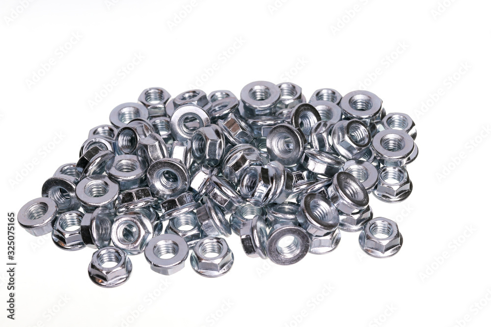 A pile of metal nuts for bolts on a white background. A pile of metal nuts for bolts on a white background.