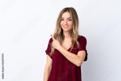 Young woman over isolated white background pointing to the side to present a product
