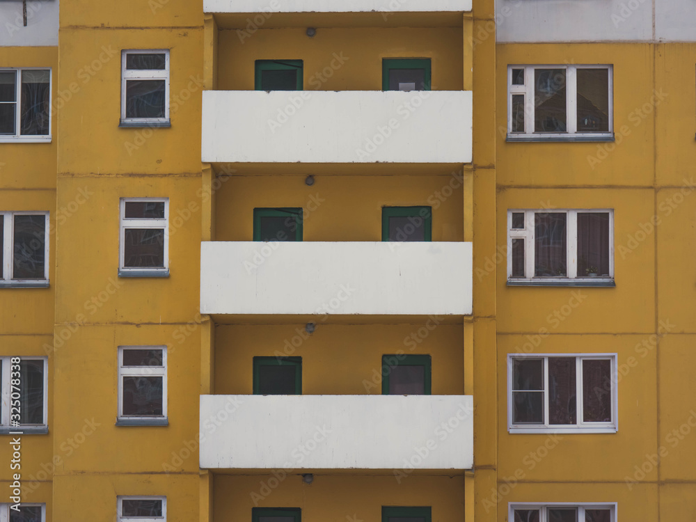 white balconies of a yellow high-rise building