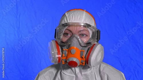 Scientist virologist in respirator. Slow motion. Woman close up look wearing protective medical mask. Concept health safety N1H1 virus protection coronavirus epidemic 2019 nCoV. Chroma key blue film. photo