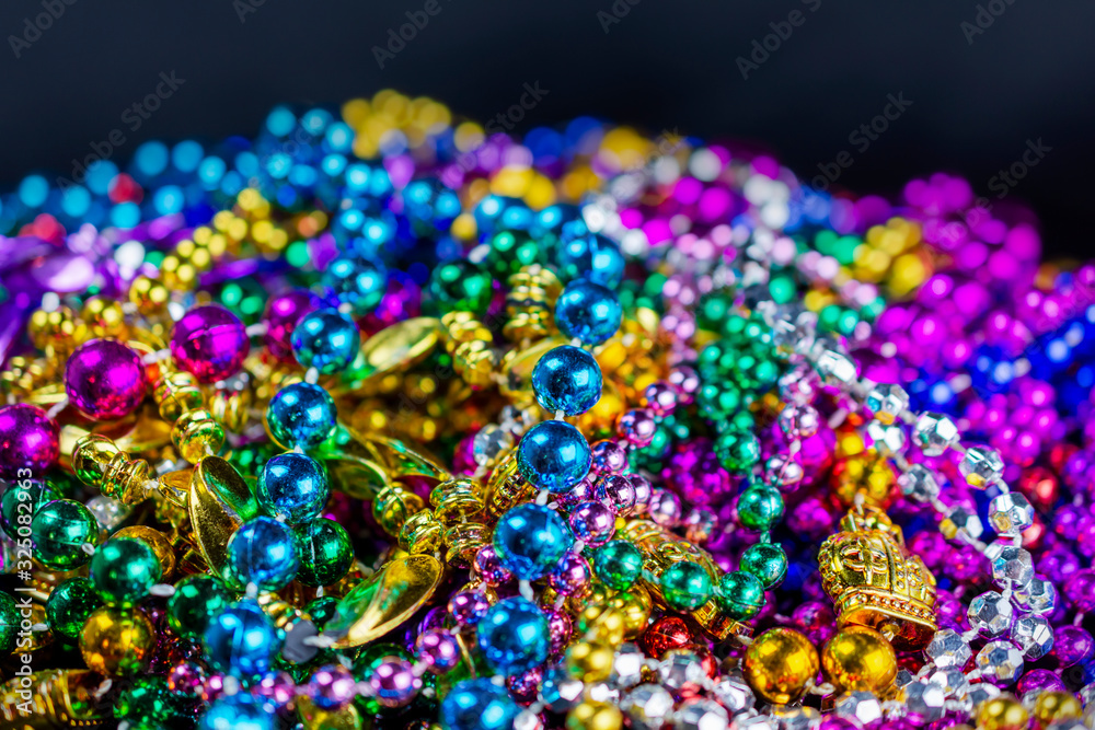 Strings of colorful festival beads with a bluish black background.  Selective focus.  Blurred foreground.  Blurred background.