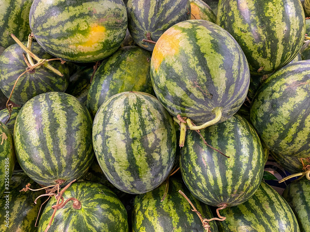 Heap of fresh stripped watermelons for sale at supermarket