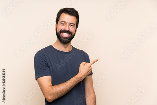 Konstfotografi Man with beard pointing to the side to present a product