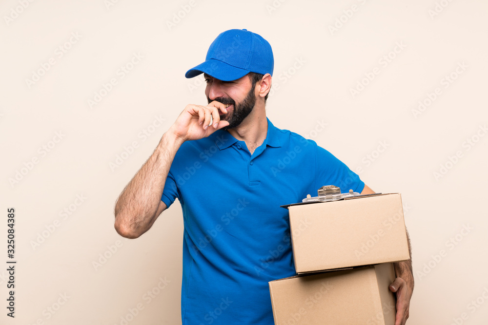 Delivery man with beard over isolated background smiling a lot Delivery man with beard over isolated background smiling a lot