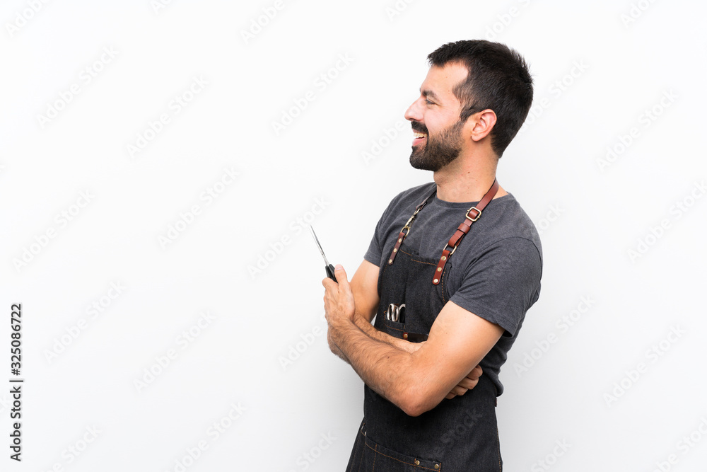 Barber man in an apron in lateral position Barber man in an apron in lateral position