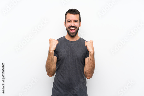 Young handsome man over isolated white background celebrating a victory in winner position