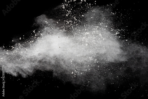 Fototapeta Naklejka Na Ścianę i Meble -  Freeze motion of white dust particles splash on black background.White powder explosion clouds.