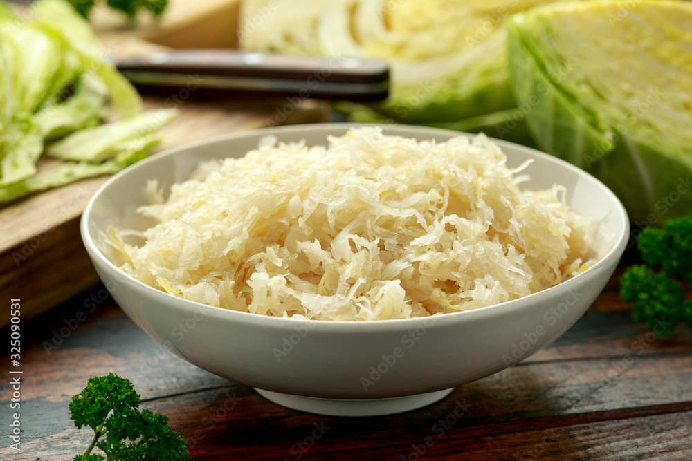 Fresh pickled cabbage in white bowl on wooden table. healthy food Fresh pickled cabbage in white bowl on wooden table. healthy food