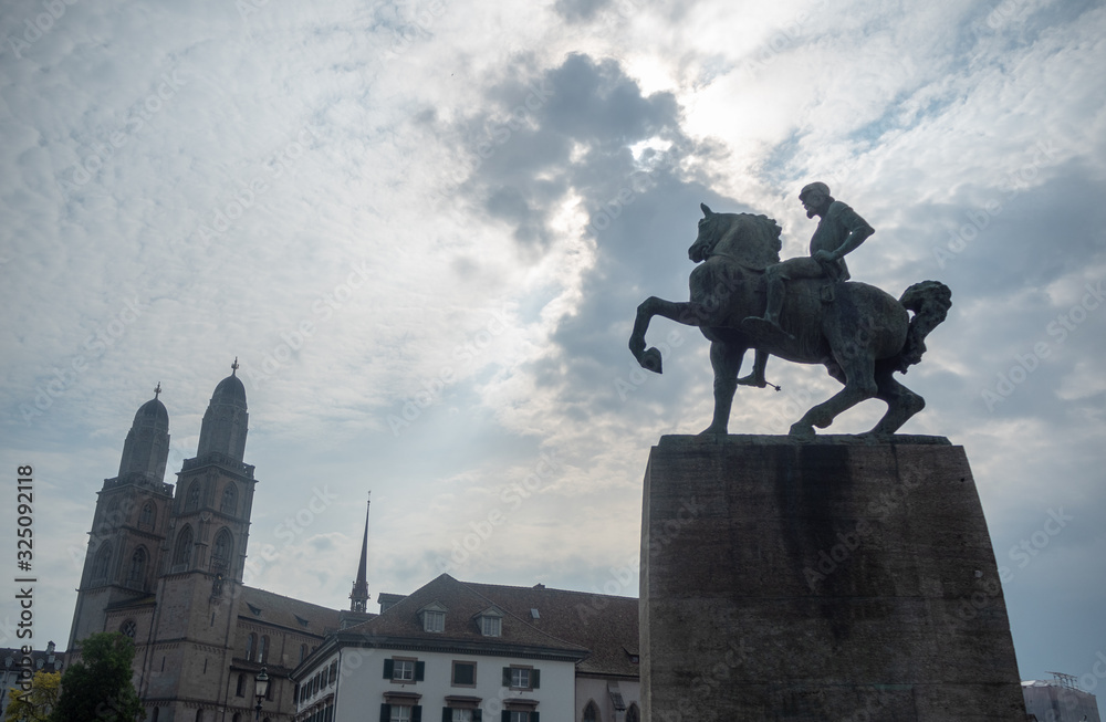 The beautiful scene of cavalier statue and medieval europe building on cloudy sky with sunlight background , copy space , Zurich , Switzerland