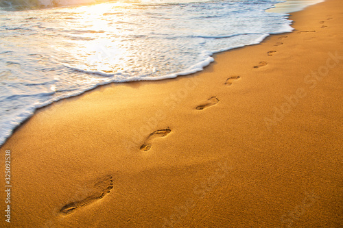 Fototapeta Naklejka Na Ścianę i Meble -  beach, wave and footprints at sunset time