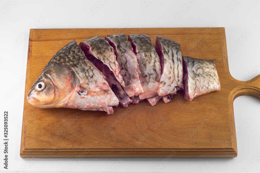 Chopped fresh crucian carp on a wooden cutting board Chopped fresh crucian carp on a wooden cutting board