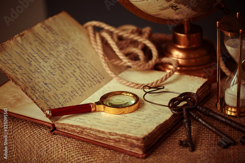 Old vintage items of the treasure hunter, traveler and discoverer - a magnifying glass, old manuscripts, a globe, keys to chests. The concept of luck, unexpected wealth, luck and romance. photo