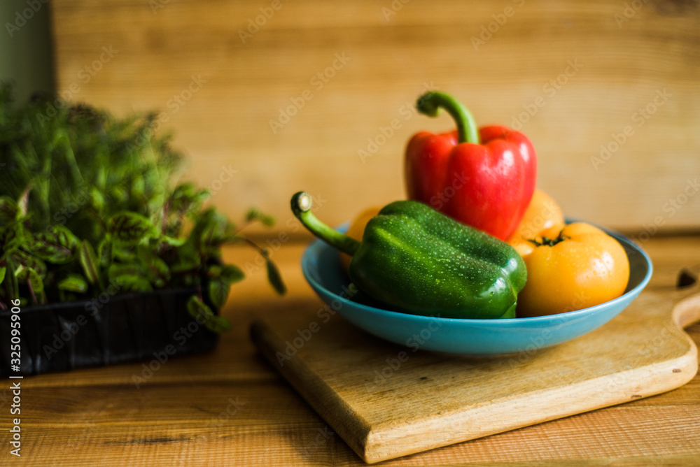 Colorful of Fresh Sweet Peppers on a Wooden Dish, Raw Organic Vegetable on a Table Ready to Cooking in The Kitchen Room. Colorful of Fresh Sweet Peppers on a Wooden Dish, Raw Organic Vegetable on a Table Ready to Cooking in The Kitchen Room.