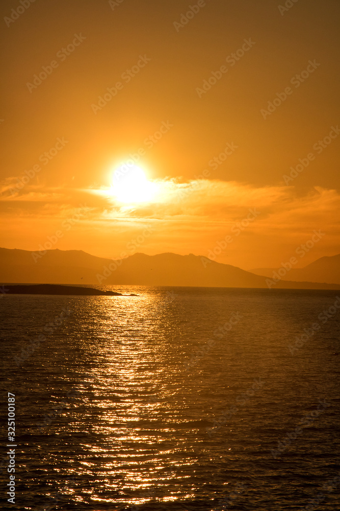 stimmungsvoller sonnenuntergang am Mittelmeer mit glühender Sonne und Inseln