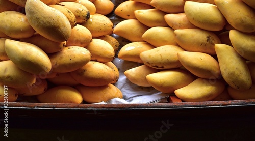 Ripe, fragrant, fresh mangoes in a boat prepared for sale to tourists. Floating market, Thailand- February 19, 2018