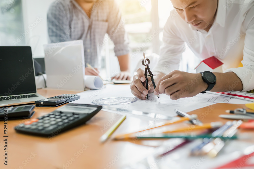 Engineer work together at meeting and planning construction projects on the desk in the office. Engineer work together at meeting and planning construction projects on the desk in the office.