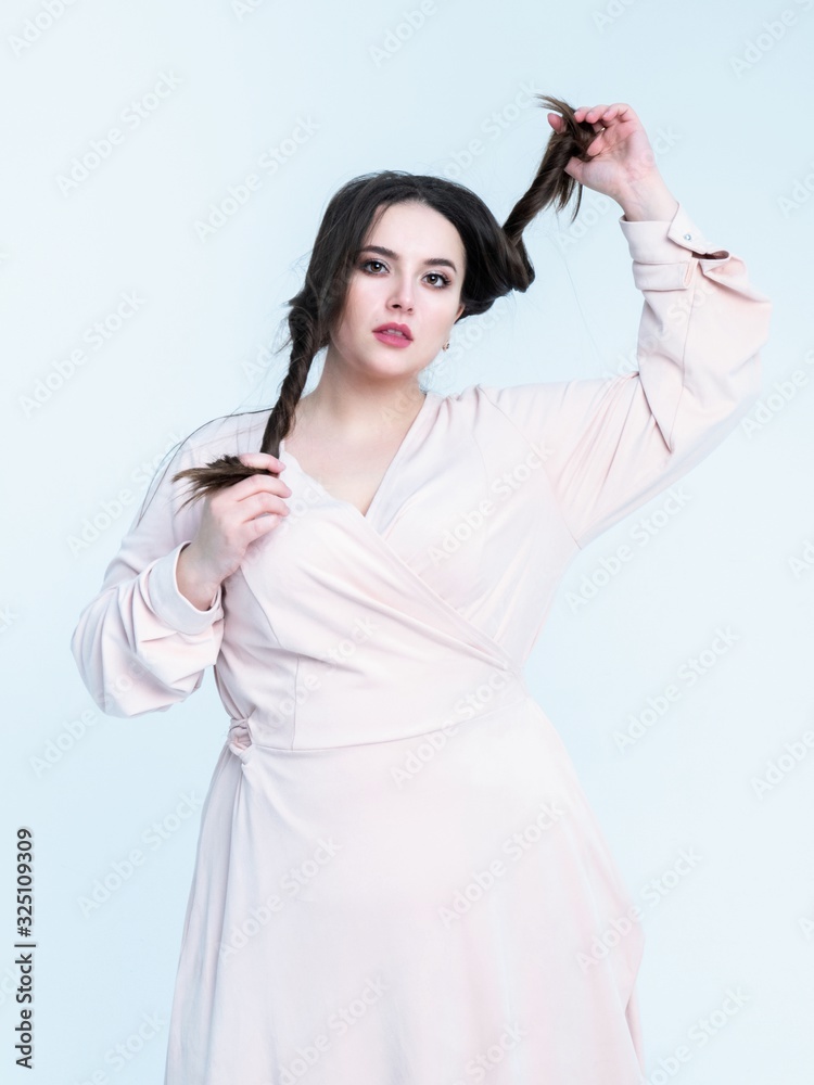 Plus Size Model plays with her long hair posing in studio Plus Size Model plays with her long hair posing in studio